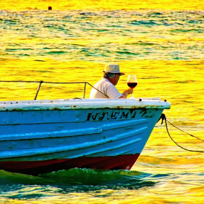 A blue boat on a yellow ocean and a man with a glass of wine-2